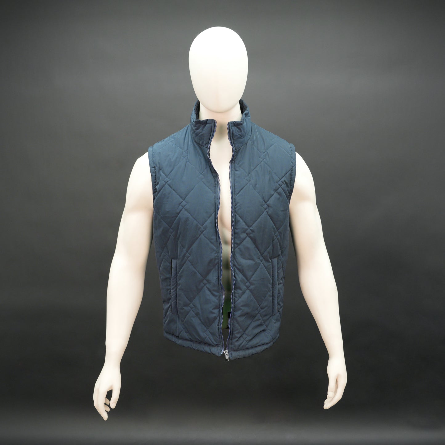 Lightweight navy sleeveless puffer vest with zip closure, side and inside pockets, for layering