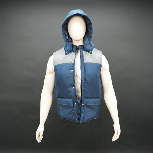 Blue-grey two-tone sleeveless puffer jacket with zip, snap buttons, hood, side and inner pockets, insulated for layering