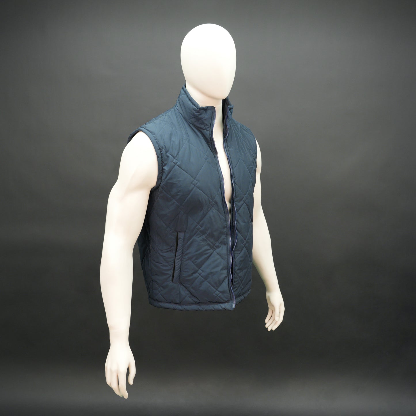 Lightweight navy sleeveless puffer vest with zip closure, side and inside pockets, for layering