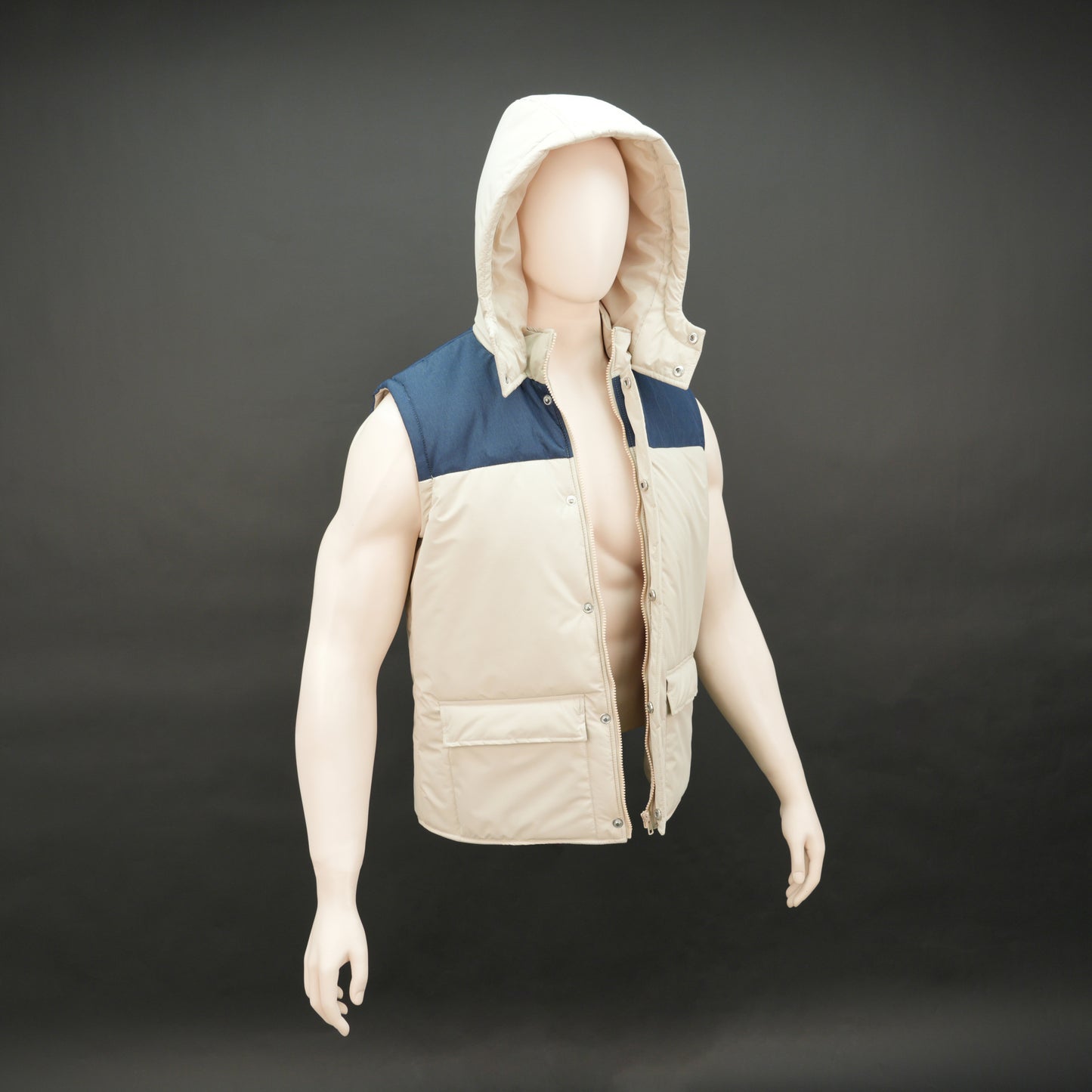 Cream-blue two-tone sleeveless puffer jacket with zip and snap closure, hood, side and inner pockets, quilted for layering