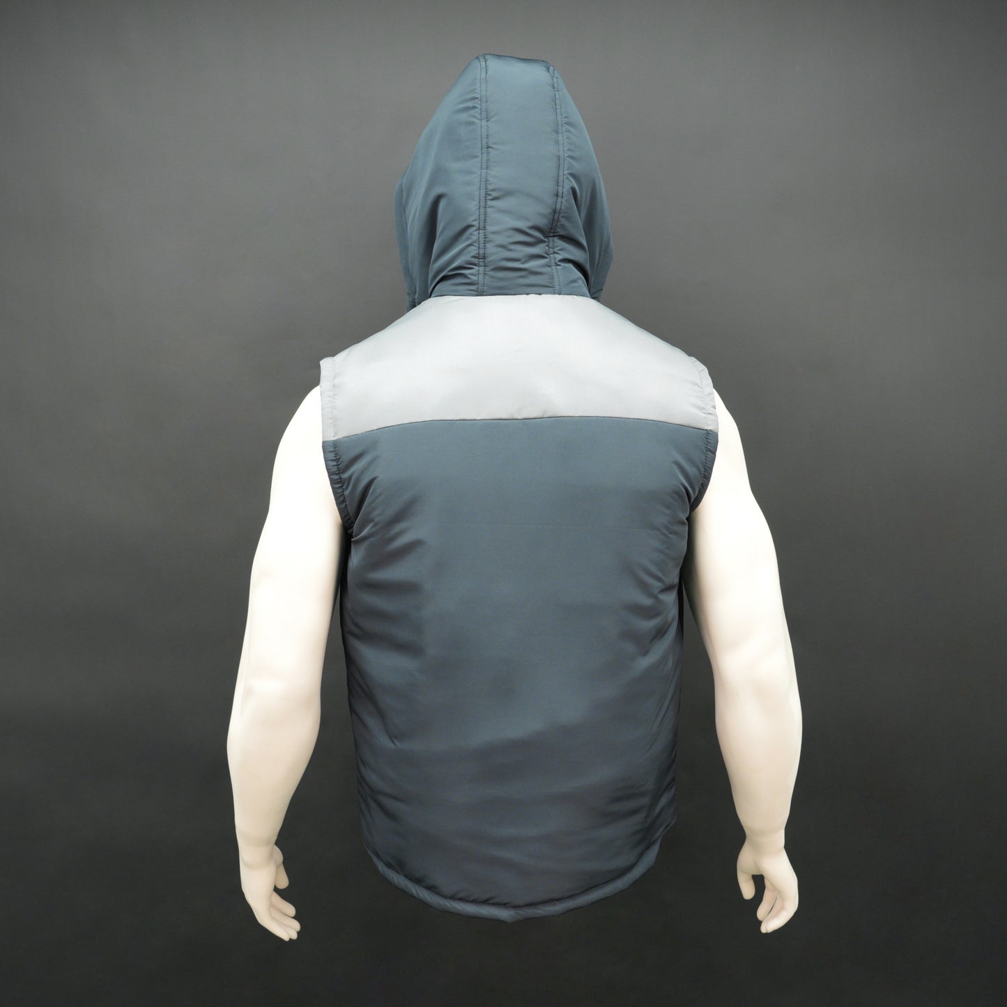 Navy-grey sleeveless puffer jacket with zip and snap closure, hood, side and inner pockets, premium fabric for warmth.