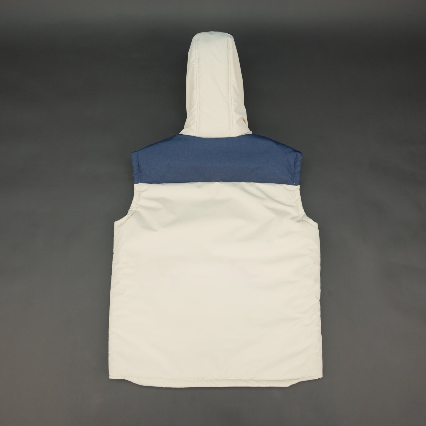 Cream-blue two-tone sleeveless puffer jacket with zip and snap closure, hood, side and inner pockets, quilted for layering