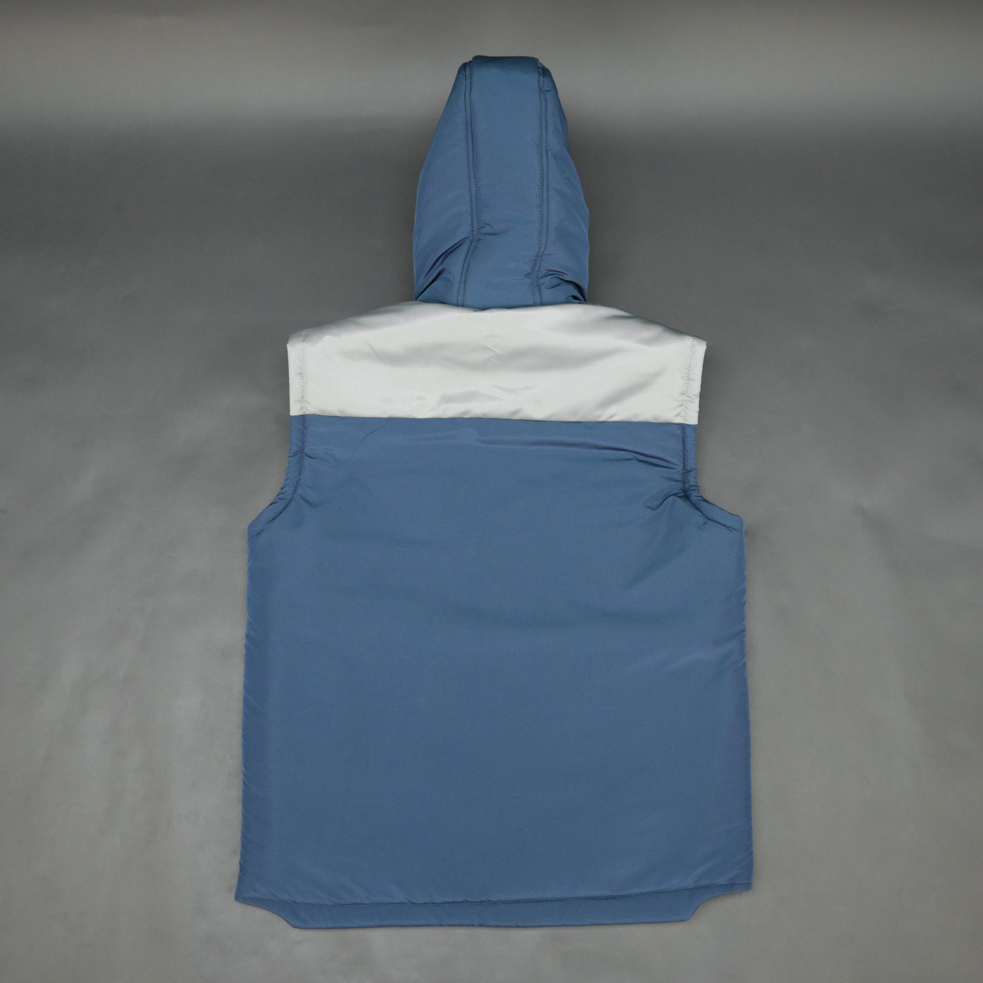 Blue-grey sleeveless two-tone puffer jacket with zip, snap buttons, hood, side and inner pockets, insulated for layering