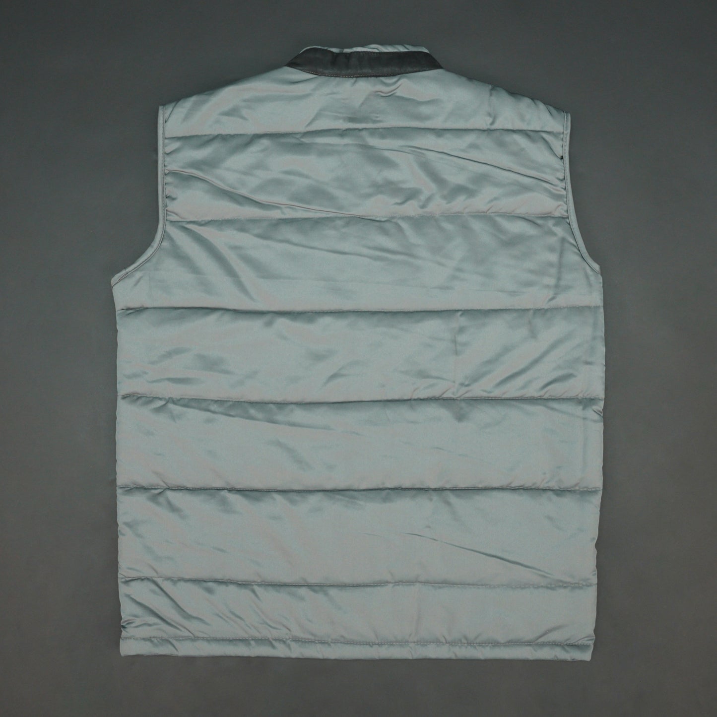 Grey jacket with a button closure, snap-button side pockets, and a single inner pocket for easy and secure storage