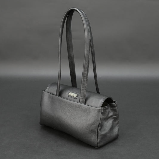 Black cow Chelsea leather bag with straps, compartments, and zipper pocket.