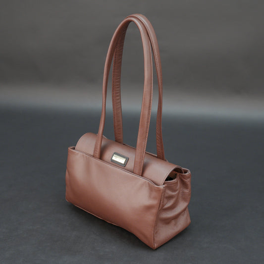 Brown cow Chelsea leather bag with straps, two compartments, and zipper pocket.