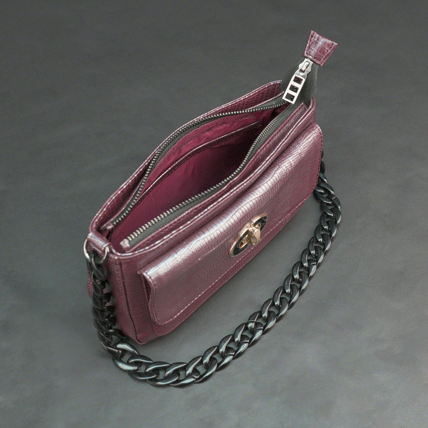 Maroon leather handbag with chain and pocket.
