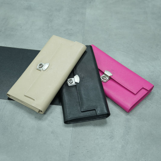 Real leather clutch available in beige, black, and pink, featuring 3 compartments, 16 card slots, a zip pocket, cash compartment, and a security key.