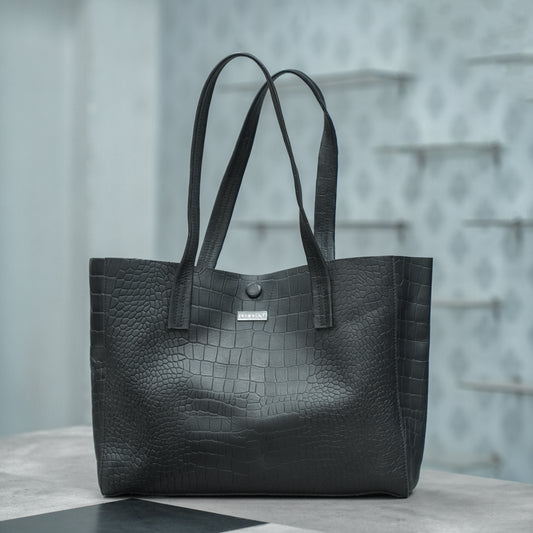 Stylish black shoulder bag with a spacious main compartment and ergonomic strap, offering comfort and functionality for work, errands, or casual outings