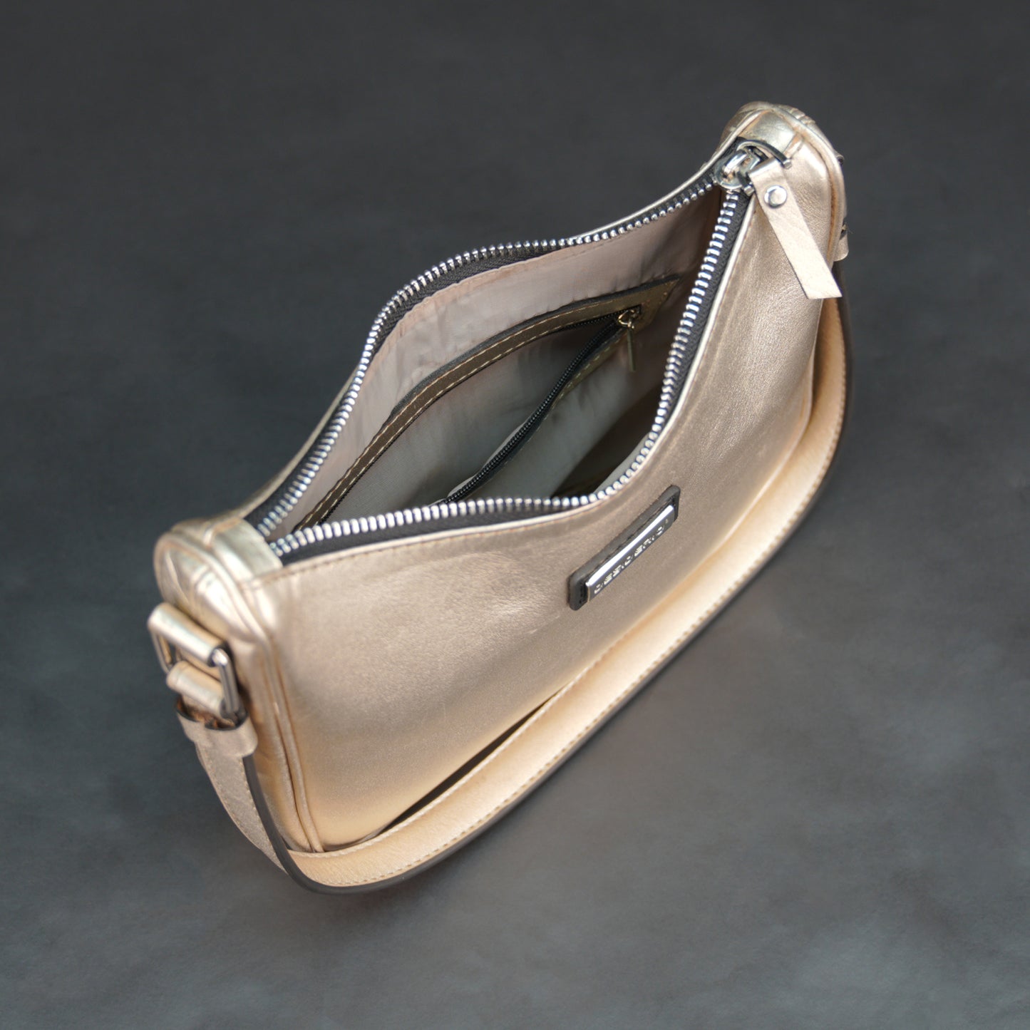 Metallic premium cow leather bag with zip closure, main compartment, and inner pocket for daily use.