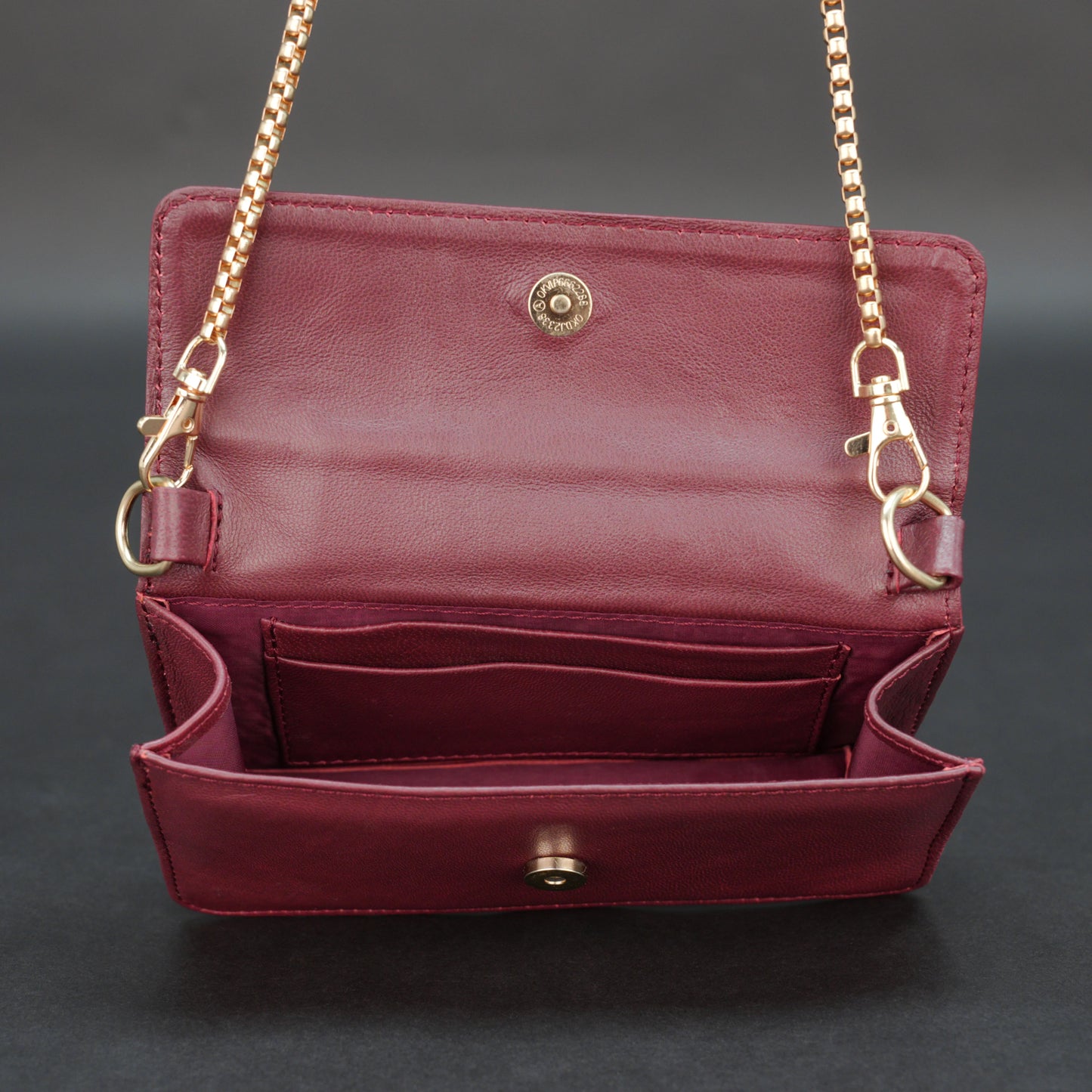 Burgundy goat leather bag with chain strap, main compartment, and inner pocket.