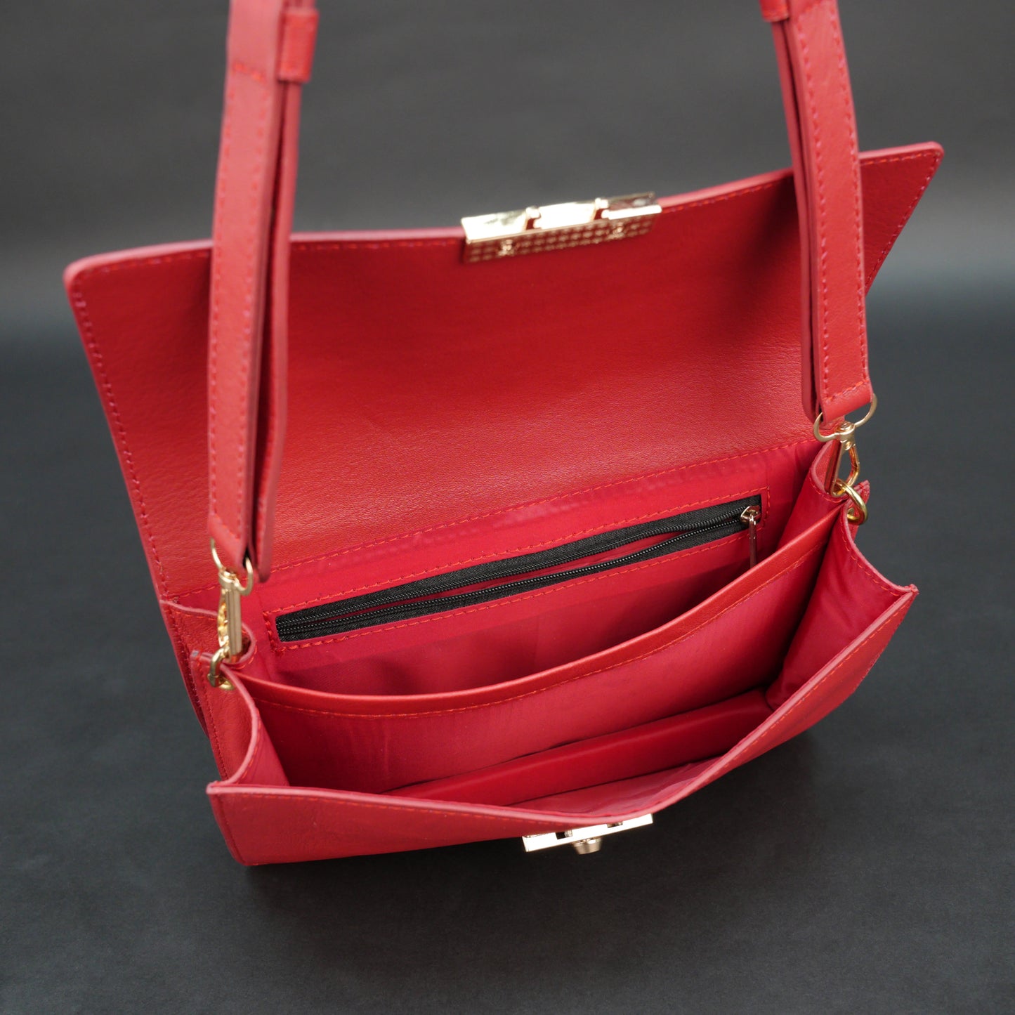 Red sheep leather bag with chain strap, two compartments, and zipper pocket.