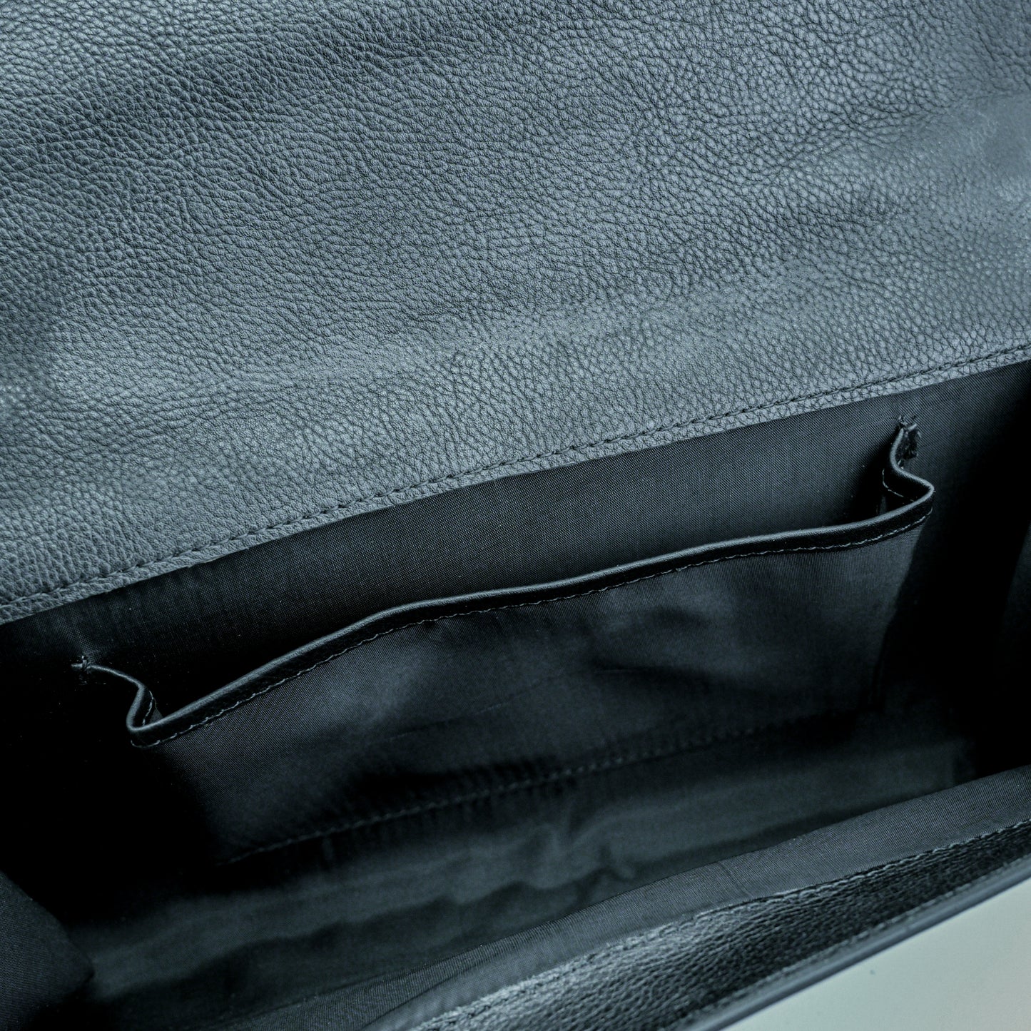 Leather grab handle bag with two open pockets, durable construction, and versatile design for everyday use