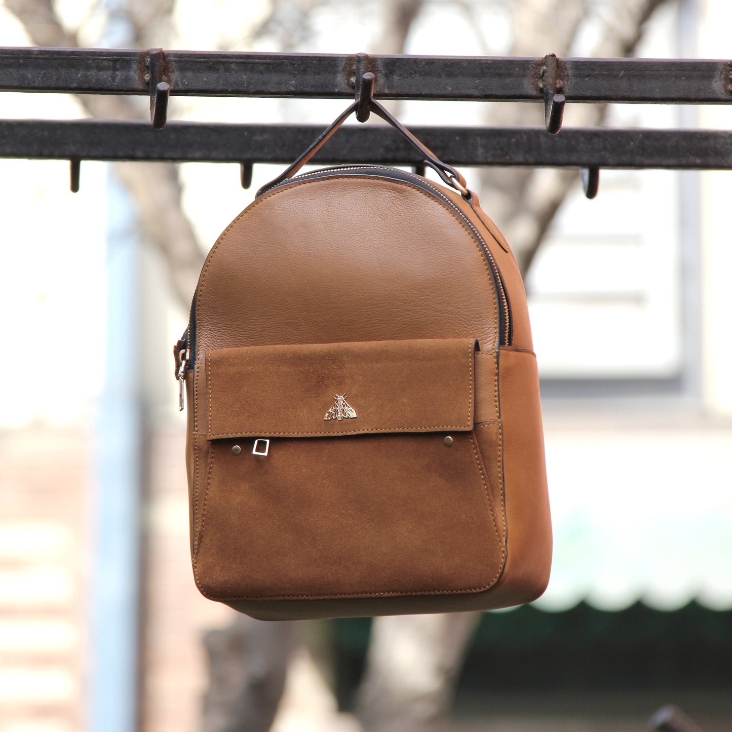 Tan genuine cowhide leather bag with minimalist design, featuring secure closures, spacious interior, and adjustable straps — crafted for durability and style