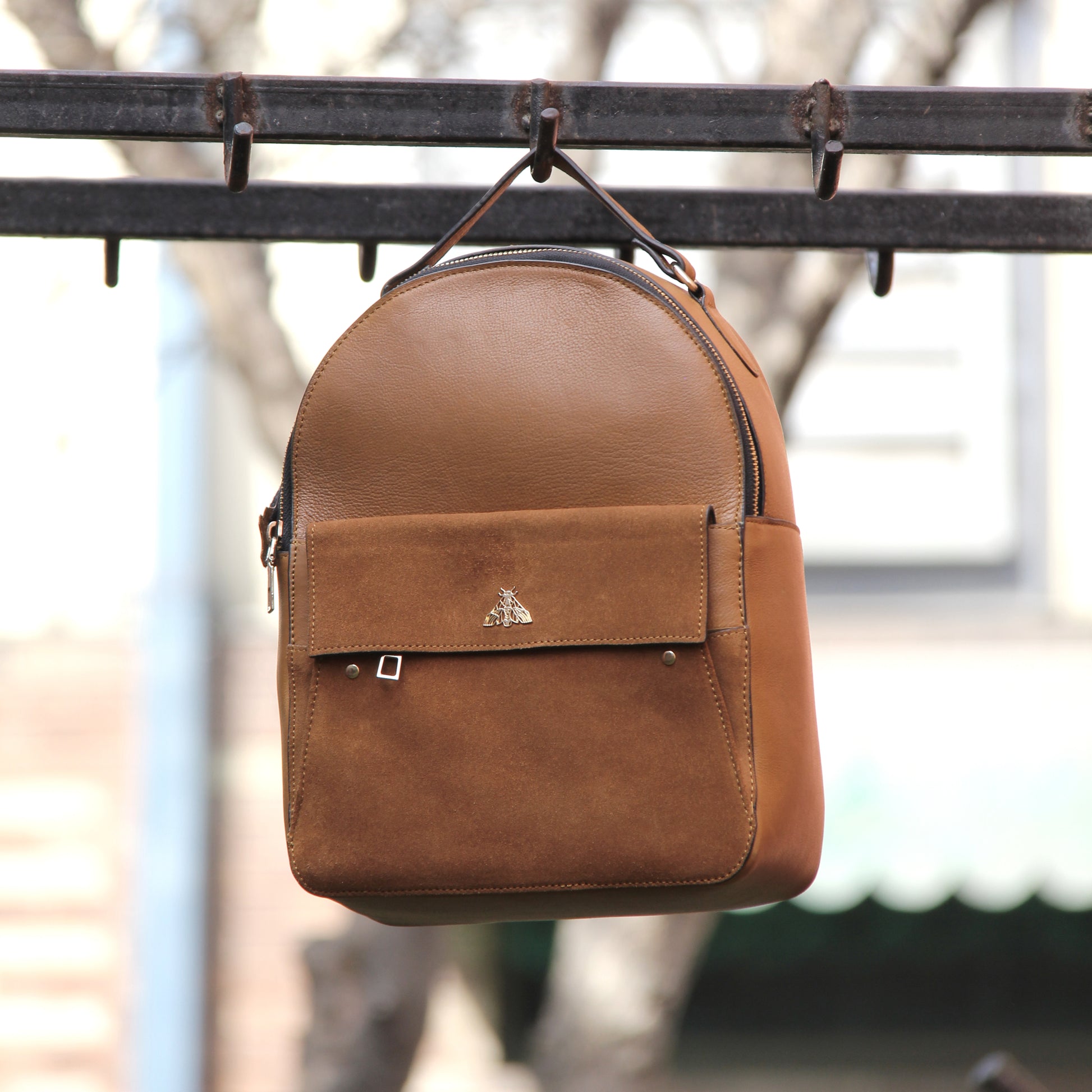 Tan genuine cowhide leather bag with minimalist design, featuring secure closures, spacious interior, and adjustable straps — crafted for durability and style