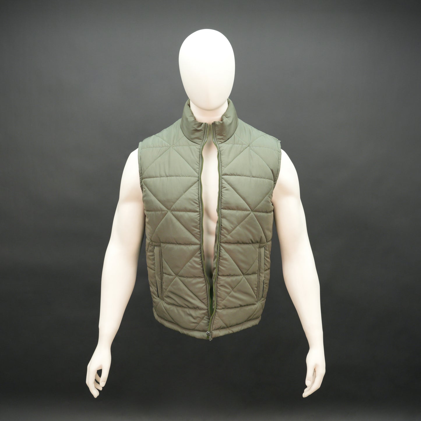 Green sleeveless puffer vest with zip closure, side and inner pockets, lightweight and ideal for layering.
