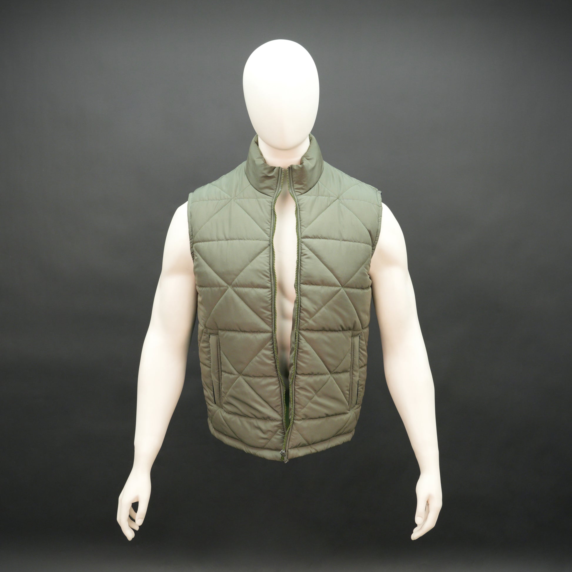 Green sleeveless puffer vest with zip closure, side and inner pockets, lightweight and ideal for layering.
