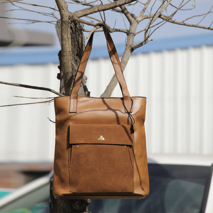 Structured cowhide leather bag in tan, featuring a minimalist exterior, multiple interior compartments, secure closures, adjustable straps, and durable craftsmanship for daily use