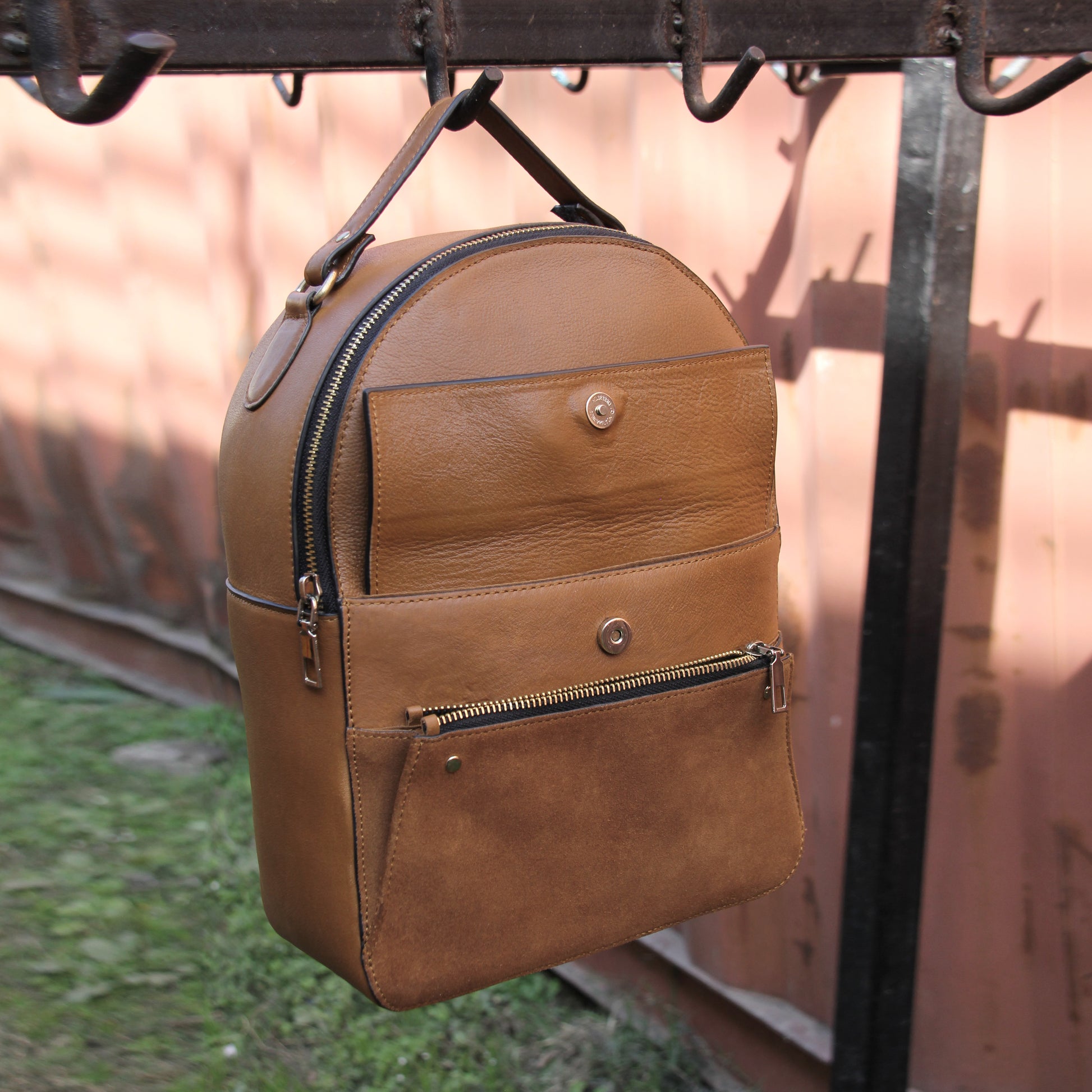 Tan genuine cowhide leather bag with minimalist design, featuring secure closures, spacious interior, and adjustable straps — crafted for durability and style