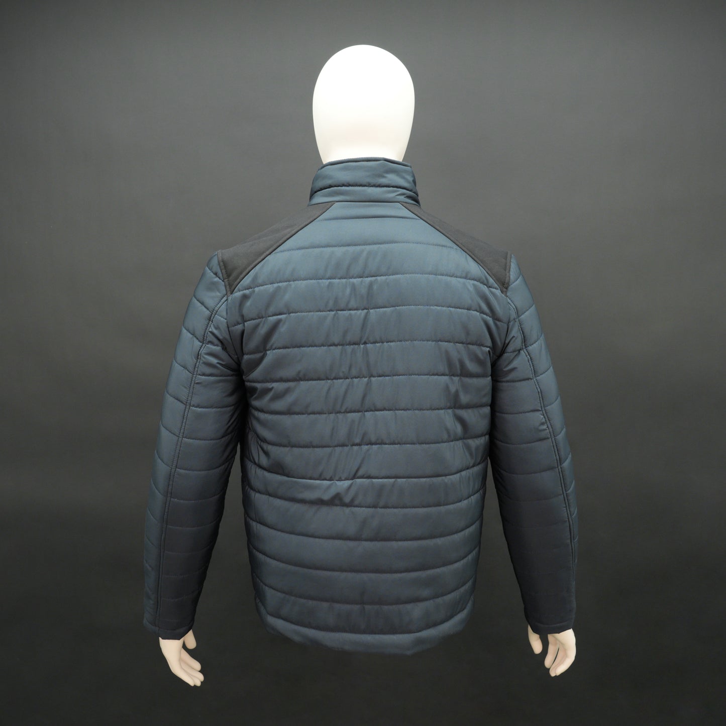 Navy full-sleeve two-tone puffer jacket with snap pockets, quilted insulation, inner compartments, and zip closure