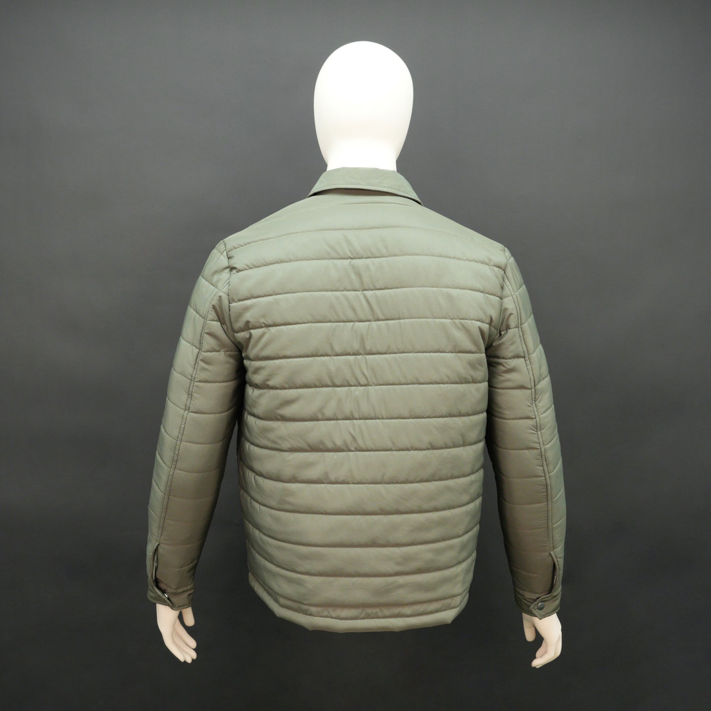 Green full-sleeve puffer jacket with snap closure, quilted padding, inner and outer pockets, designed for everyday comfort.