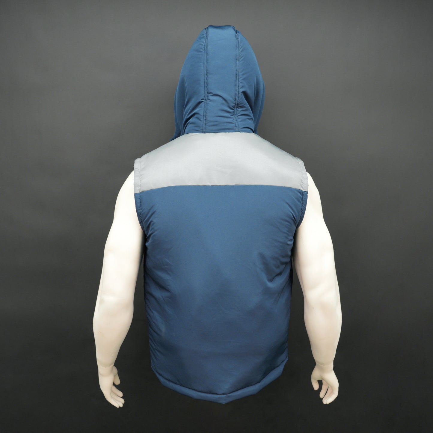 Blue-grey two-tone sleeveless puffer jacket with zip, snap buttons, hood, side and inner pockets, insulated for layering