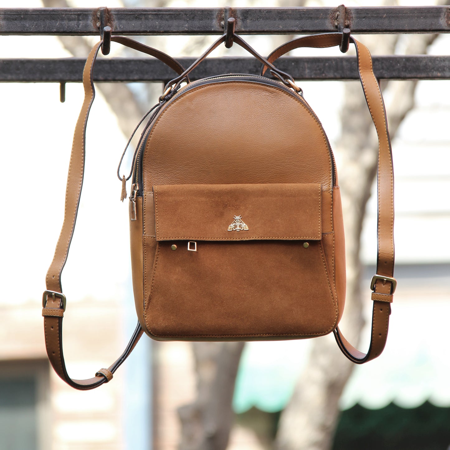 Tan genuine cowhide leather bag with minimalist design, featuring secure closures, spacious interior, and adjustable straps — crafted for durability and style