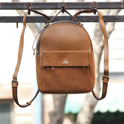 Tan genuine cowhide leather bag with minimalist design, featuring secure closures, spacious interior, and adjustable straps — crafted for durability and style