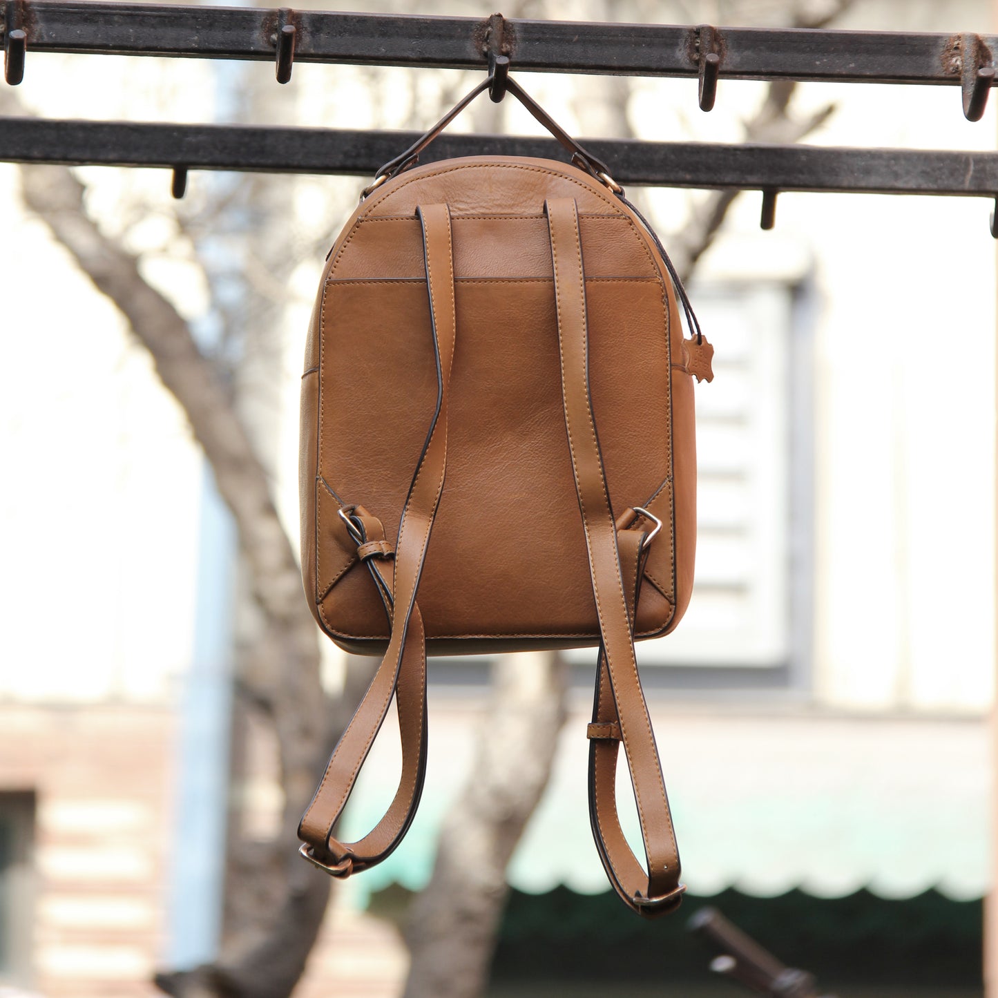 Tan genuine cowhide leather bag with minimalist design, featuring secure closures, spacious interior, and adjustable straps — crafted for durability and style