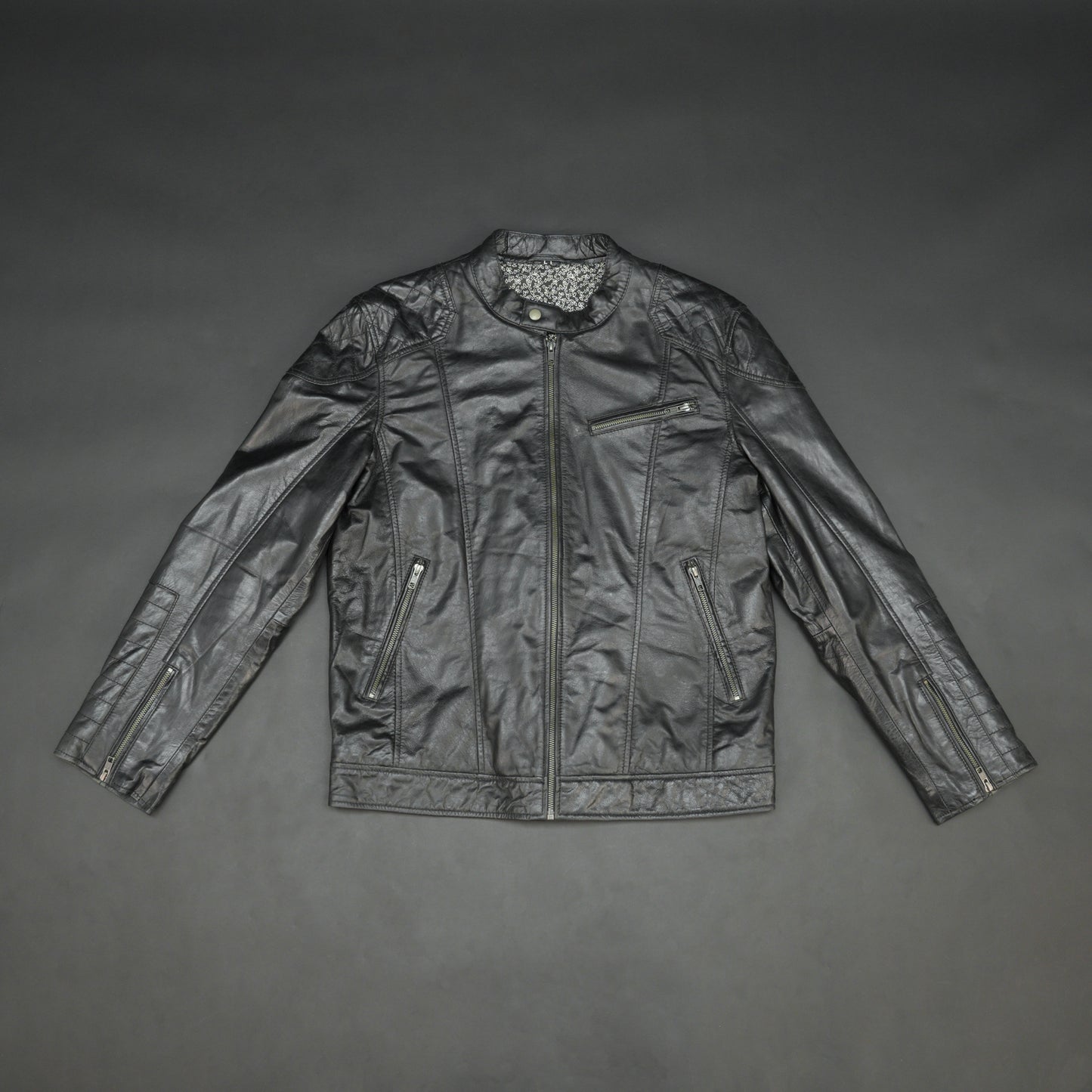 Black jacket model 2212 featuring a front zip closure, two side pockets, an upper right-side front pocket, zip cuffs, an inside zipper pocket, and a snap-button collar. Sleek, modern design with versatile everyday style