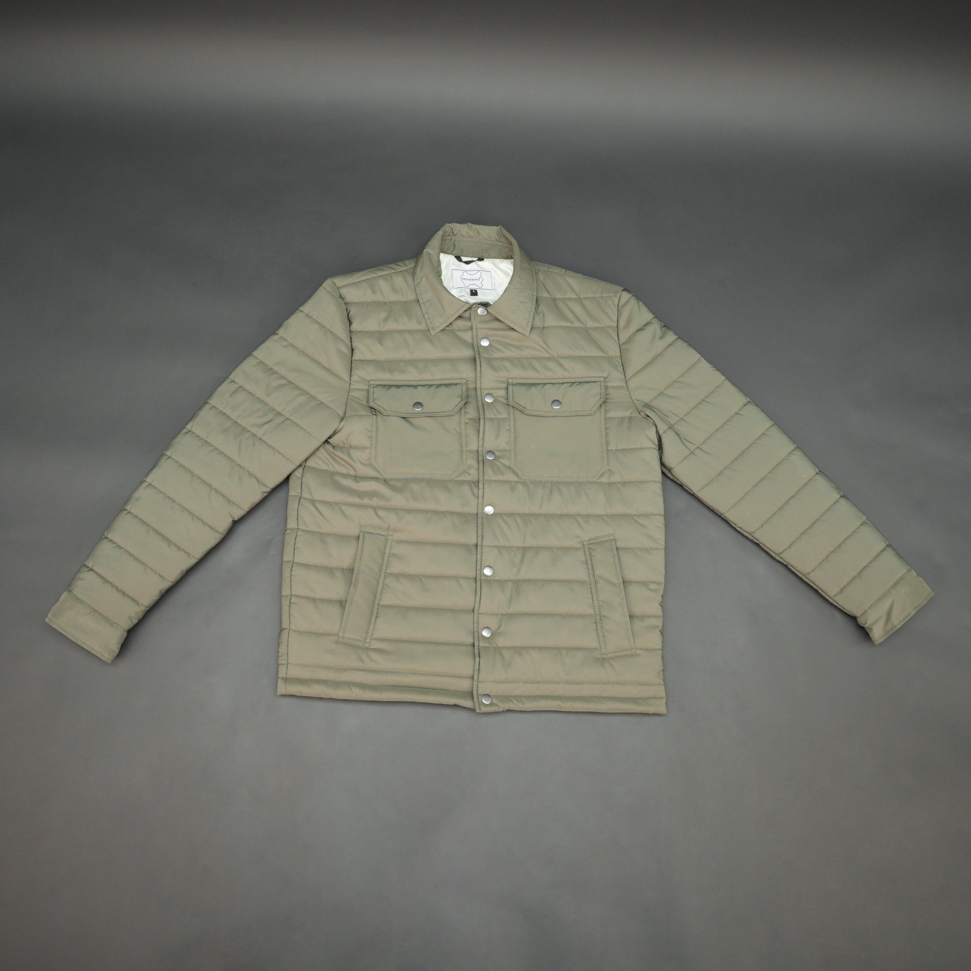 Green full-sleeve puffer jacket with snap closure, quilted padding, inner and outer pockets, designed for everyday comfort.