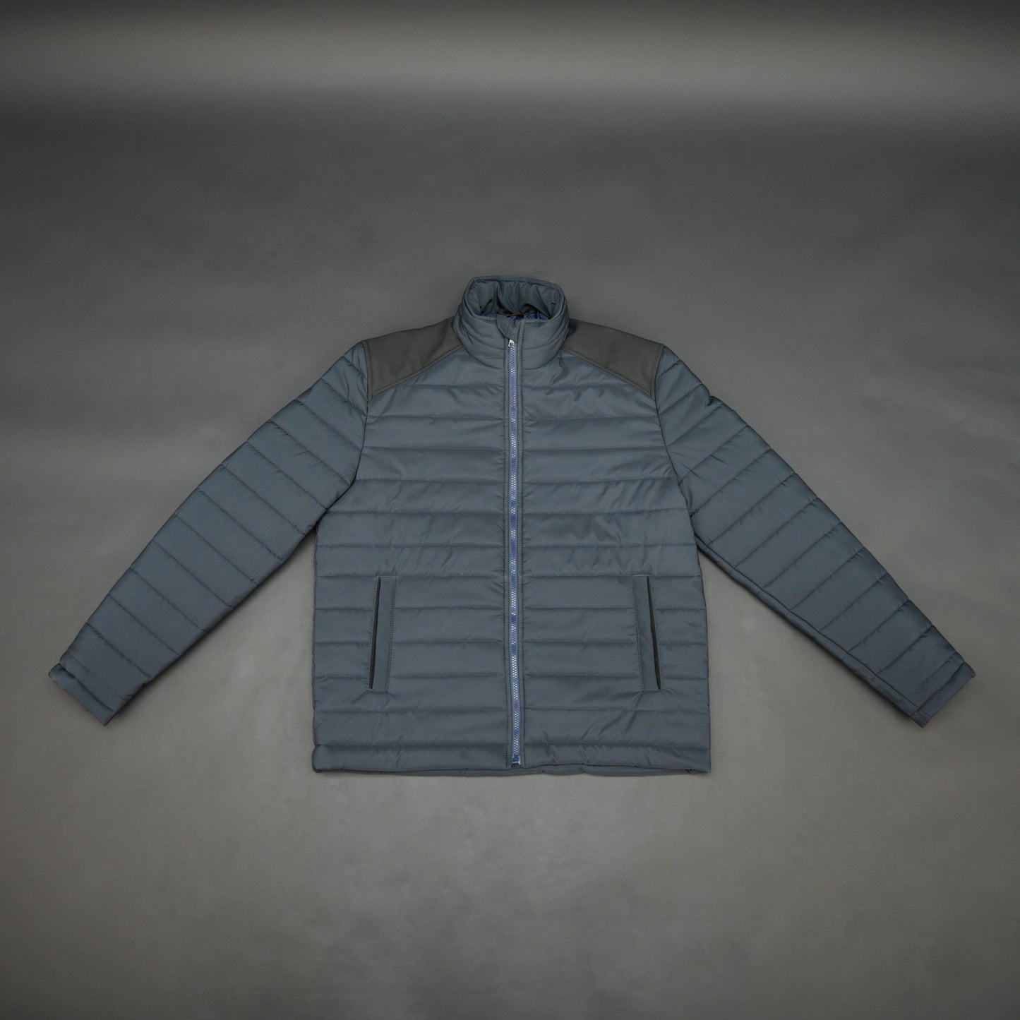 Navy full-sleeve two-tone puffer jacket with snap pockets, quilted insulation, inner compartments, and zip closure