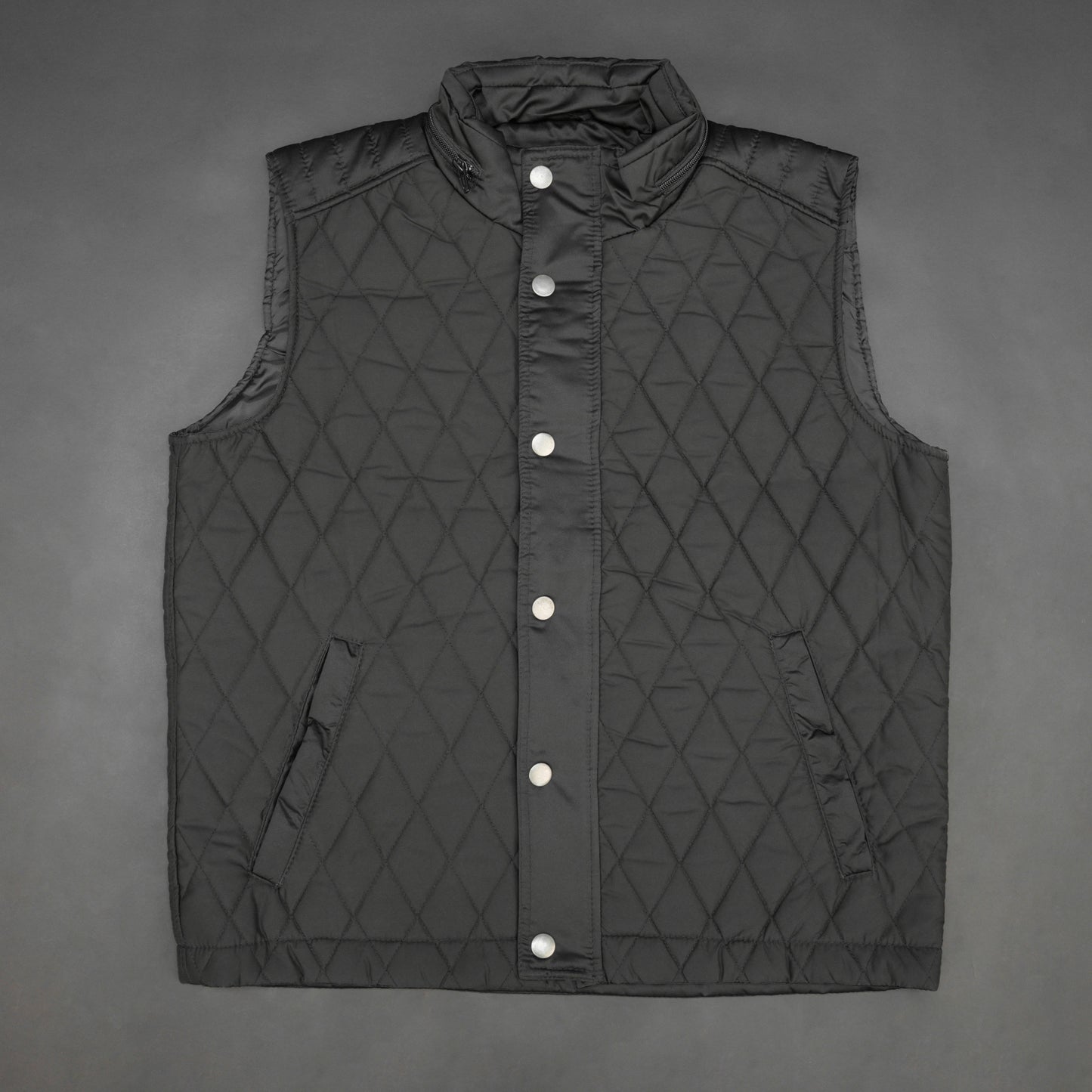 Black vest with a zip closure and snap button, two side pockets with snap buttons, and one inside pocket for secure storage