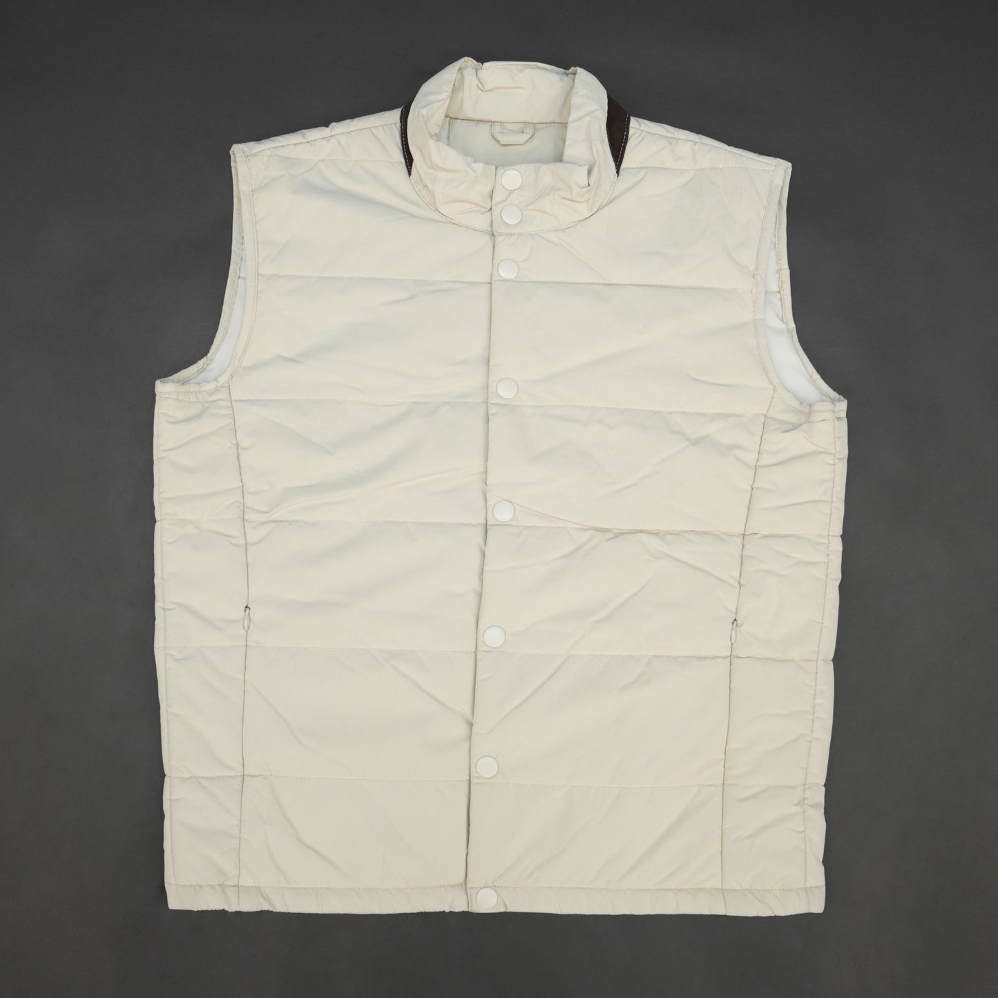 Beige jacket featuring a button closure, two snap-button side pockets, and one inner pocket for convenient, secure storage