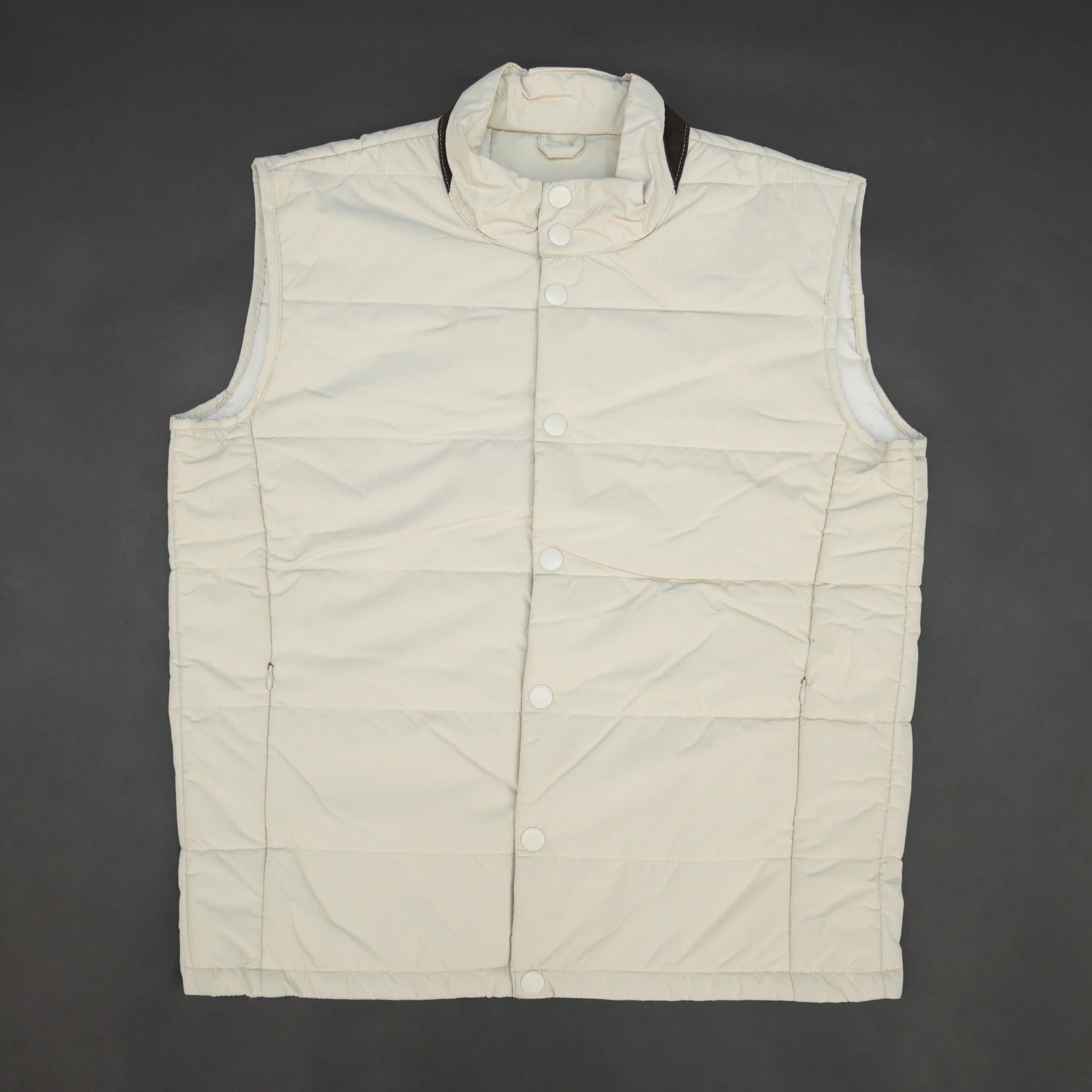 Beige jacket featuring a button closure, two snap-button side pockets, and one inner pocket for convenient, secure storage