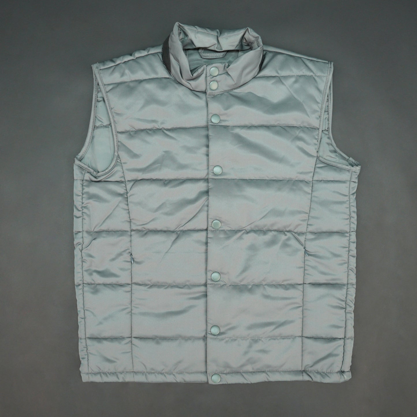 Grey jacket with a button closure, snap-button side pockets, and a single inner pocket for easy and secure storage