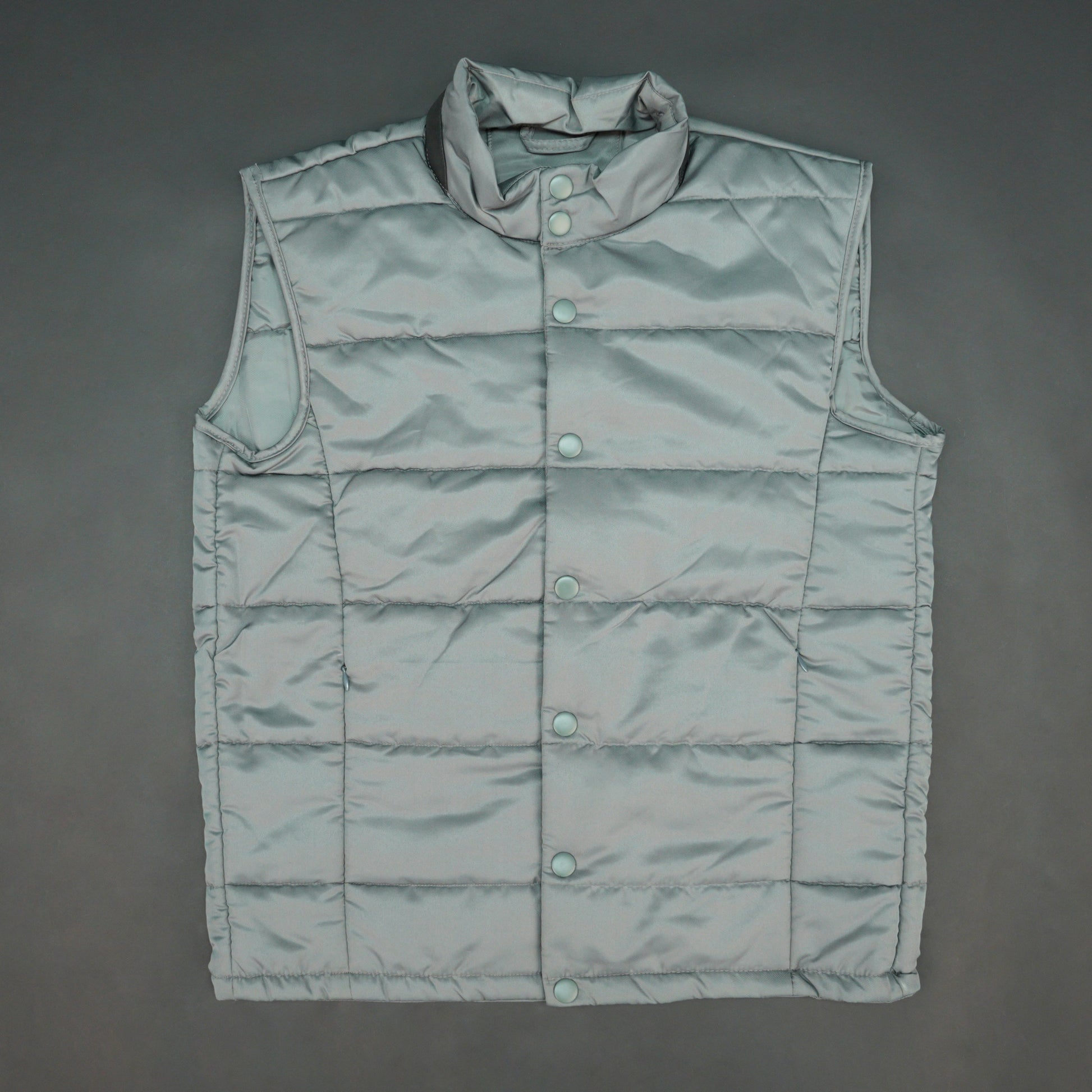 Grey jacket with a button closure, snap-button side pockets, and a single inner pocket for easy and secure storage