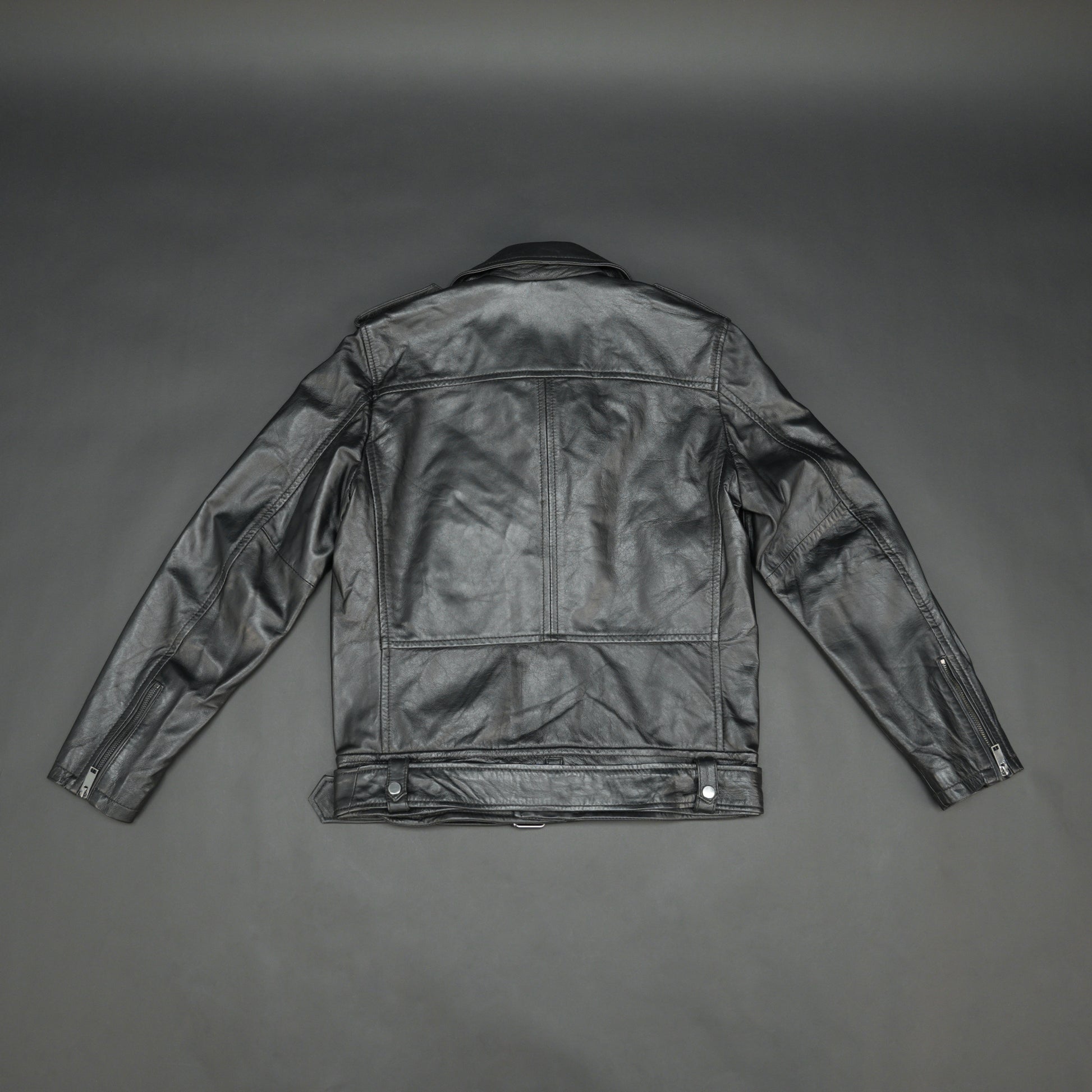 Black sheep leather jacket with adjustable waist belt, two front side pockets, one inside pocket, and zip flap closure