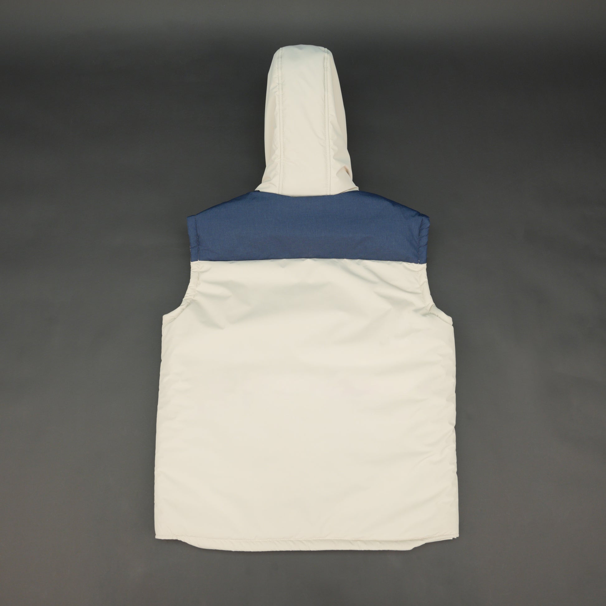 Cream-blue two-tone sleeveless puffer jacket with zip and snap closure, hood, side and inner pockets, quilted for layering