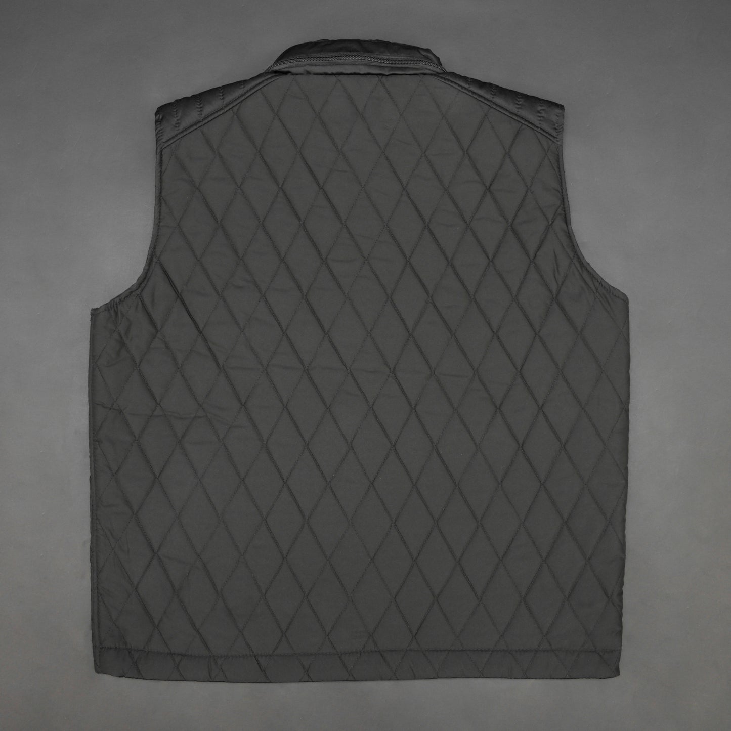 Black vest with a zip closure and snap button, two side pockets with snap buttons, and one inside pocket for secure storage