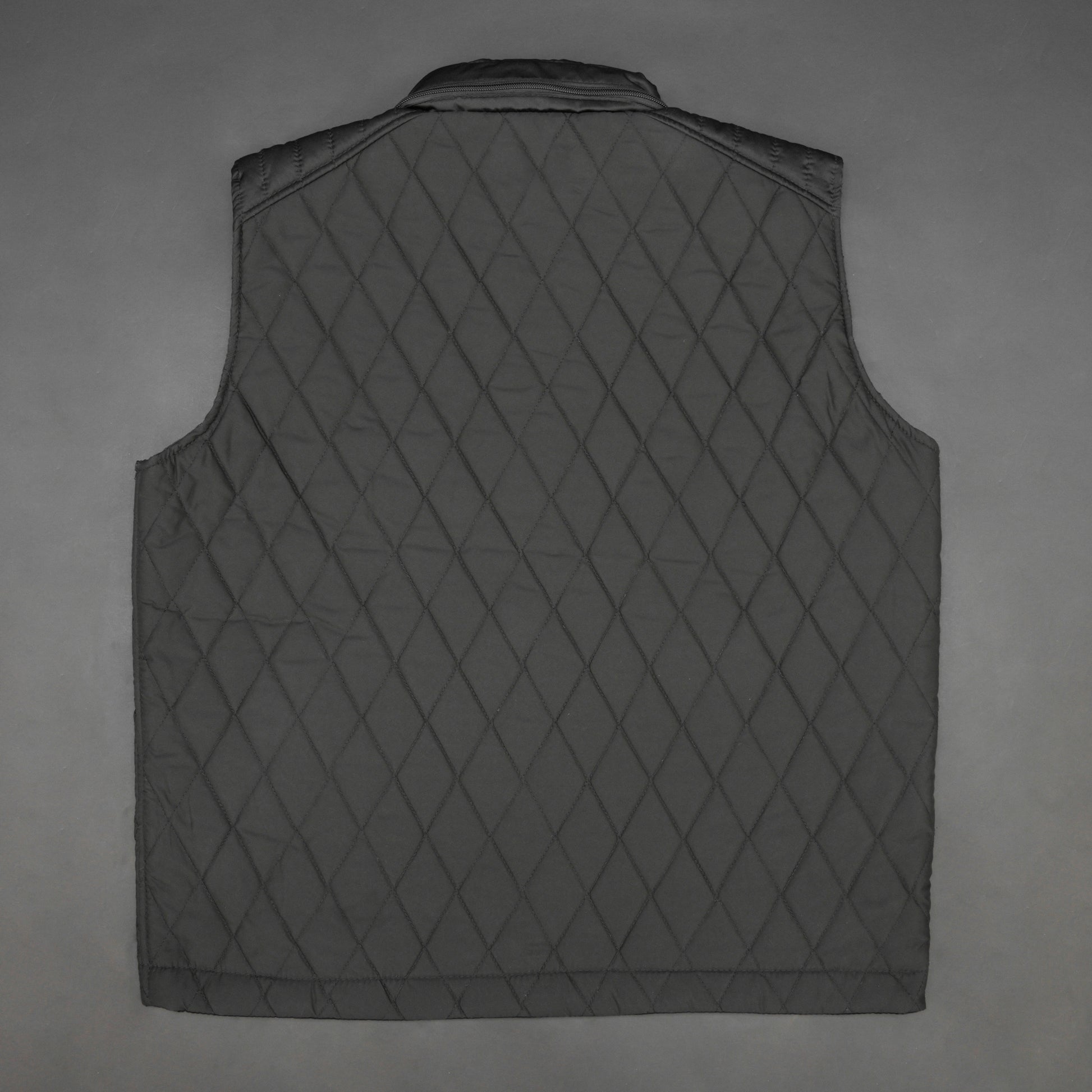 Black vest with a zip closure and snap button, two side pockets with snap buttons, and one inside pocket for secure storage