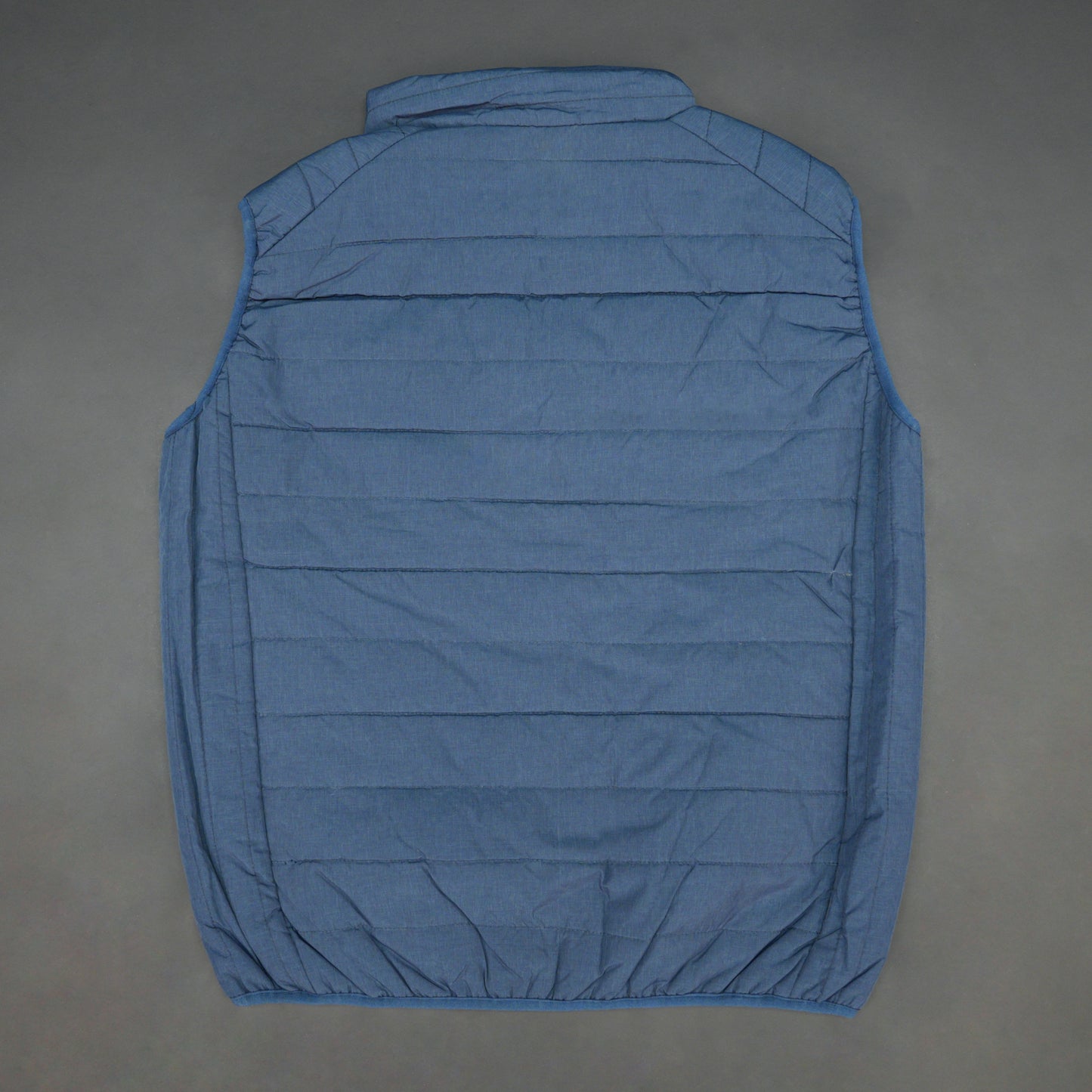 Blue garment with a full zip front, snap-button side pockets, and two interior pockets designed for secure and easy storage