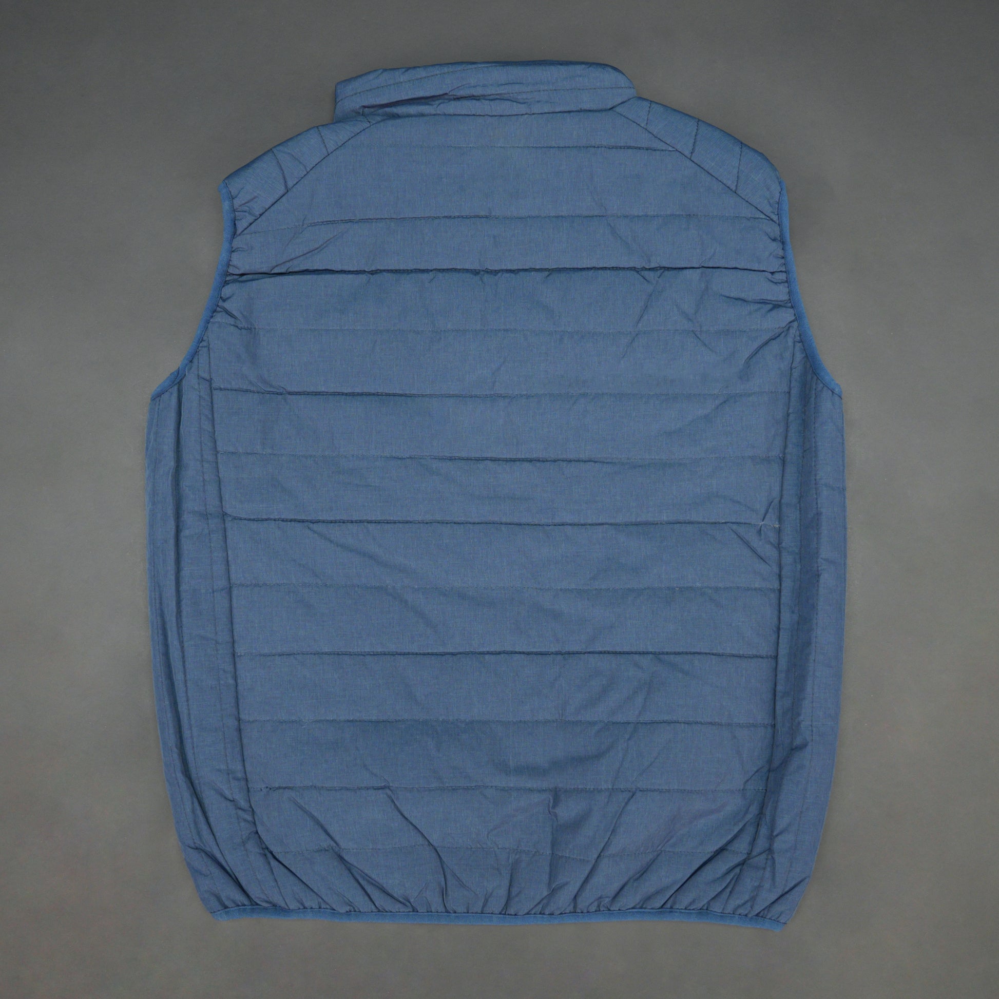Blue garment with a full zip front, snap-button side pockets, and two interior pockets designed for secure and easy storage