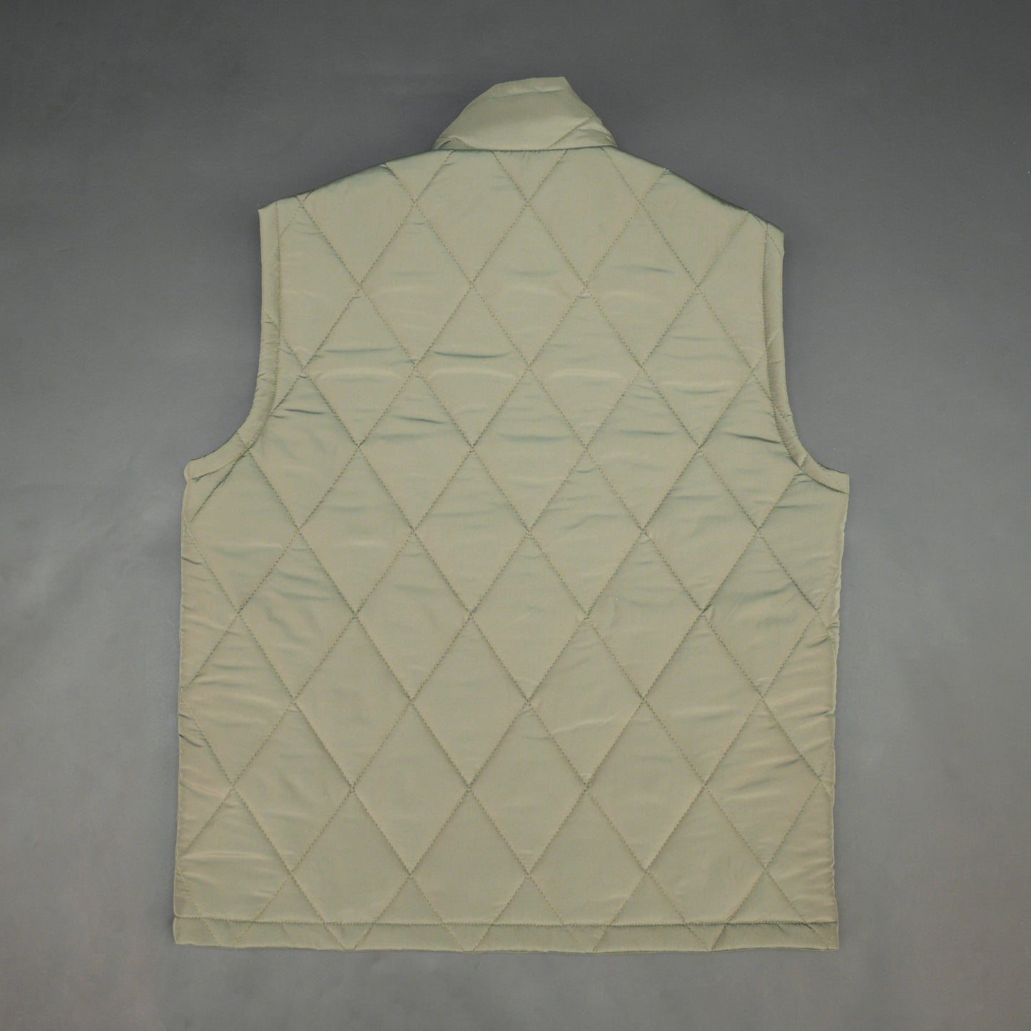 Green sleeveless puffer vest with zip, side and inside pockets, lightweight for layering
