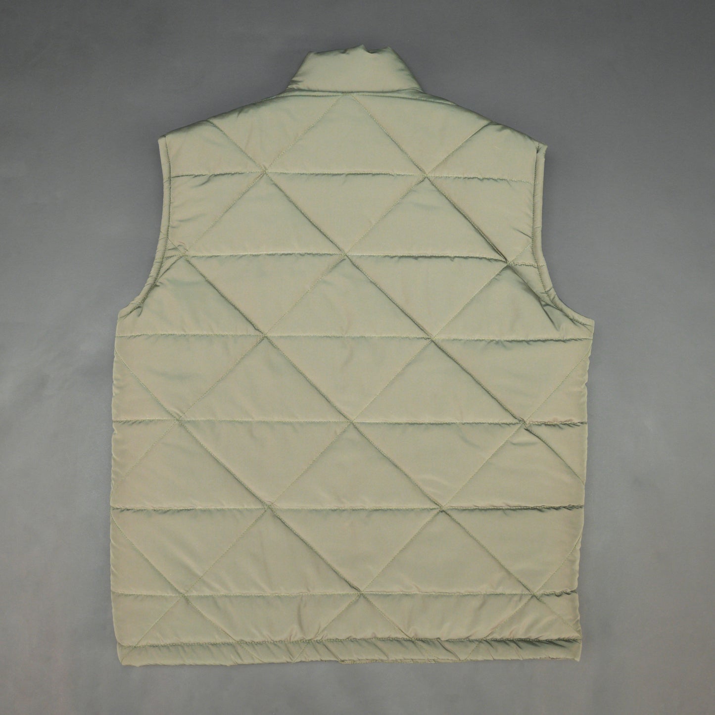 Green sleeveless puffer vest with zip closure, side and inner pockets, lightweight and ideal for layering.