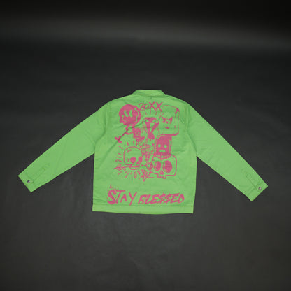 Green denim jacket with bold ‘Stay Blessed’ graphic on the back, button-down front, adjustable cuffs, and side pockets for casual wear