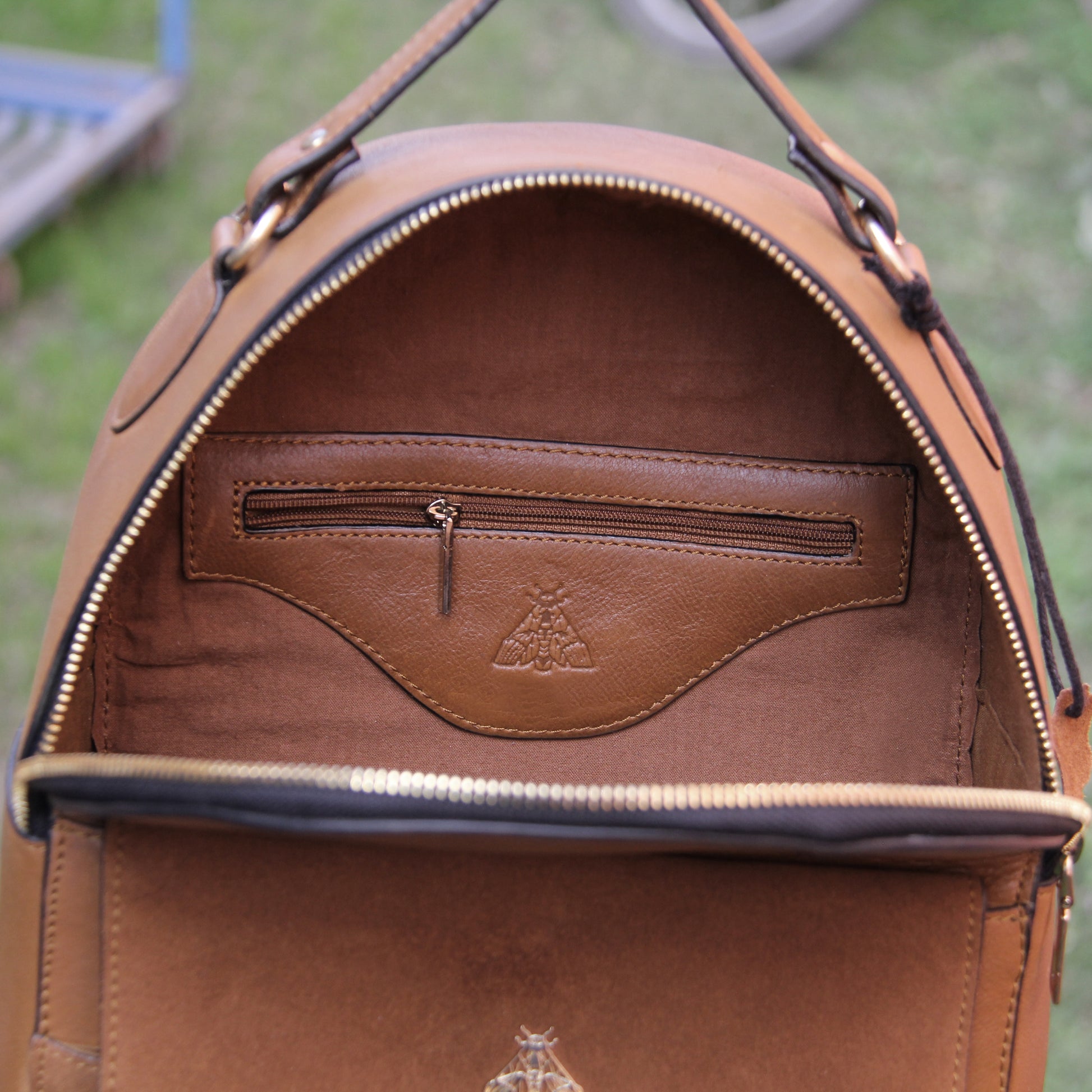 Tan genuine cowhide leather bag with minimalist design, featuring secure closures, spacious interior, and adjustable straps — crafted for durability and style