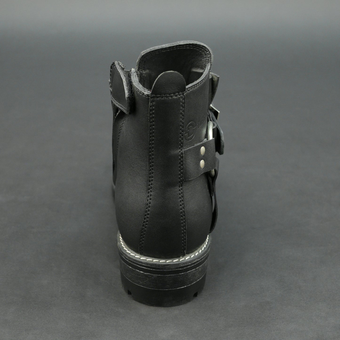 Matte black bovine leather biker boots with side buckle and zipper.