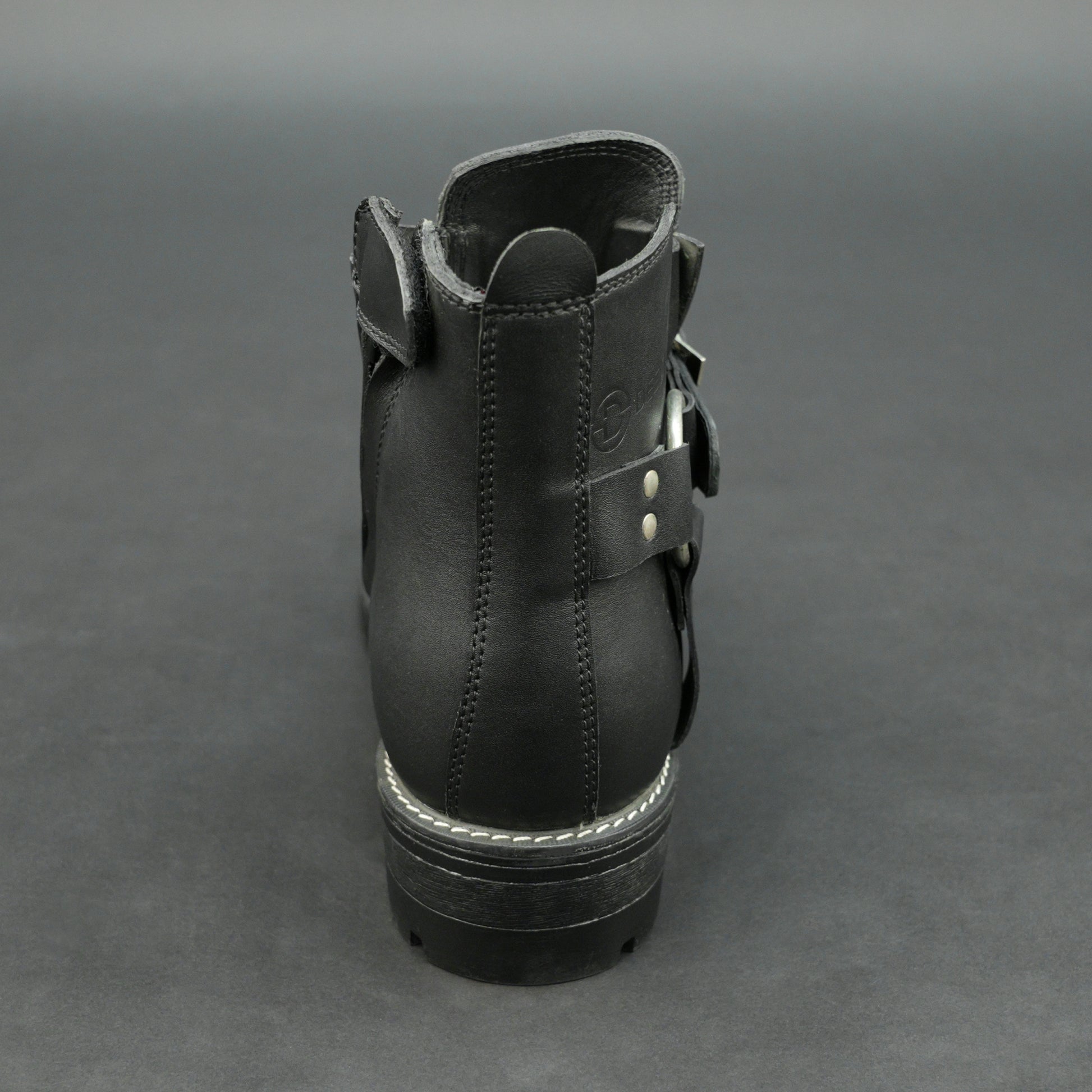 Matte black bovine leather biker boots with side buckle and zipper.