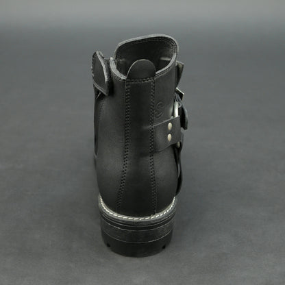 Matte black bovine leather biker boots with side buckle and zipper.